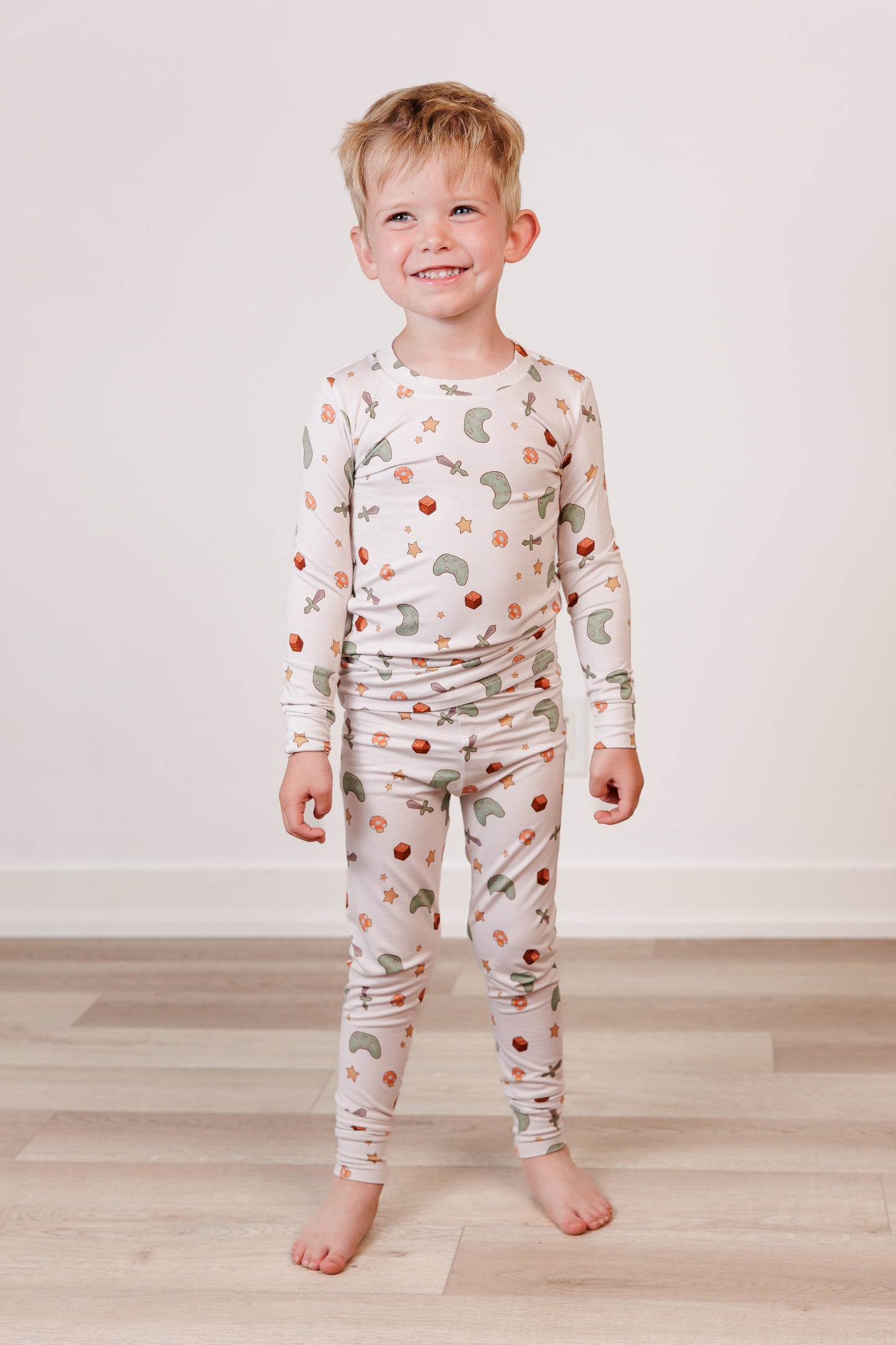 Child wearing a long-sleeve pajama set with a pattern on a plain background